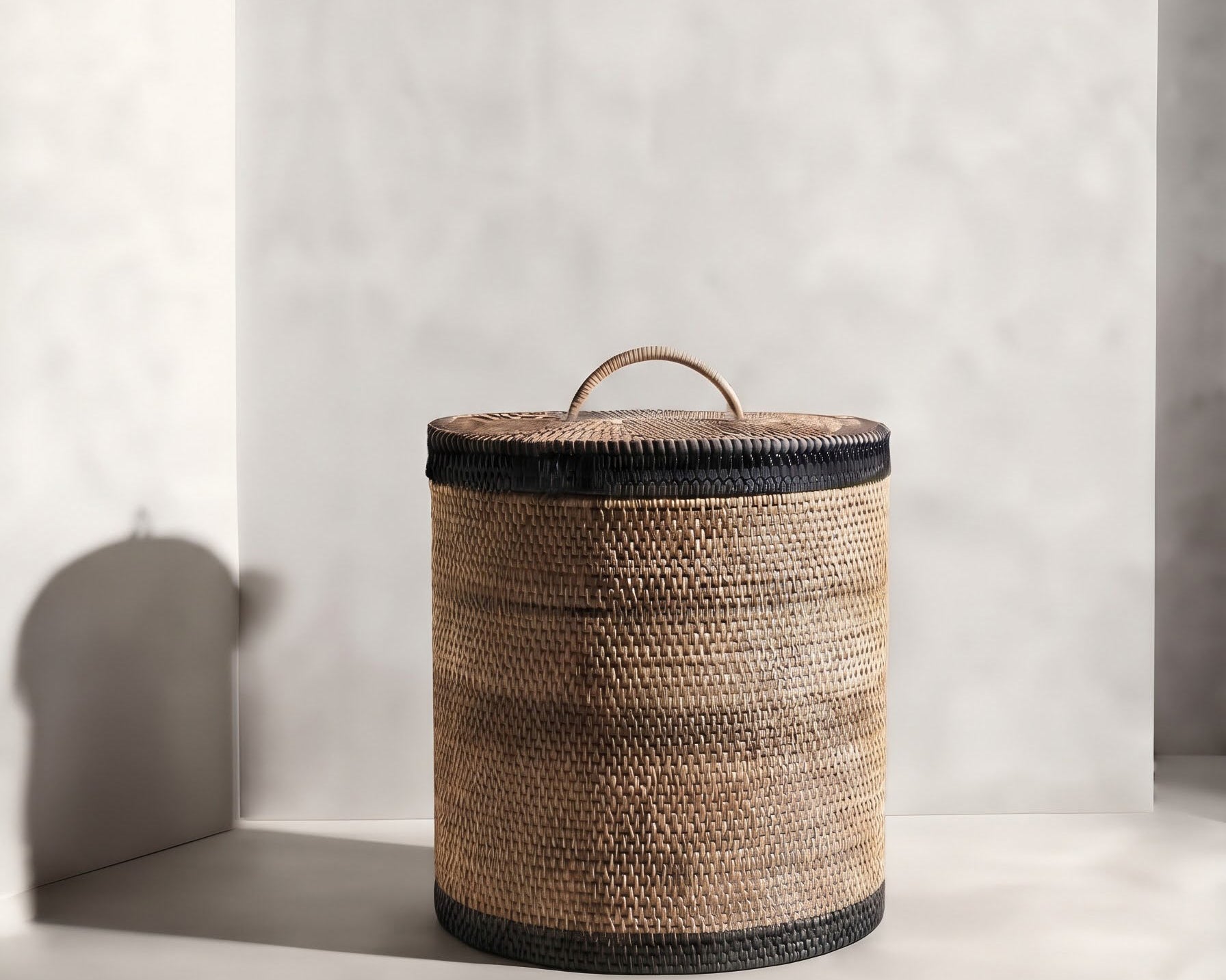 Hand‑woven rattan waste paper basket with fitted lid and dark olive detailing | Anboise