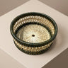 Round woven wine coaster with a dark green outer rim and a natural rattan inner weave | Anboise