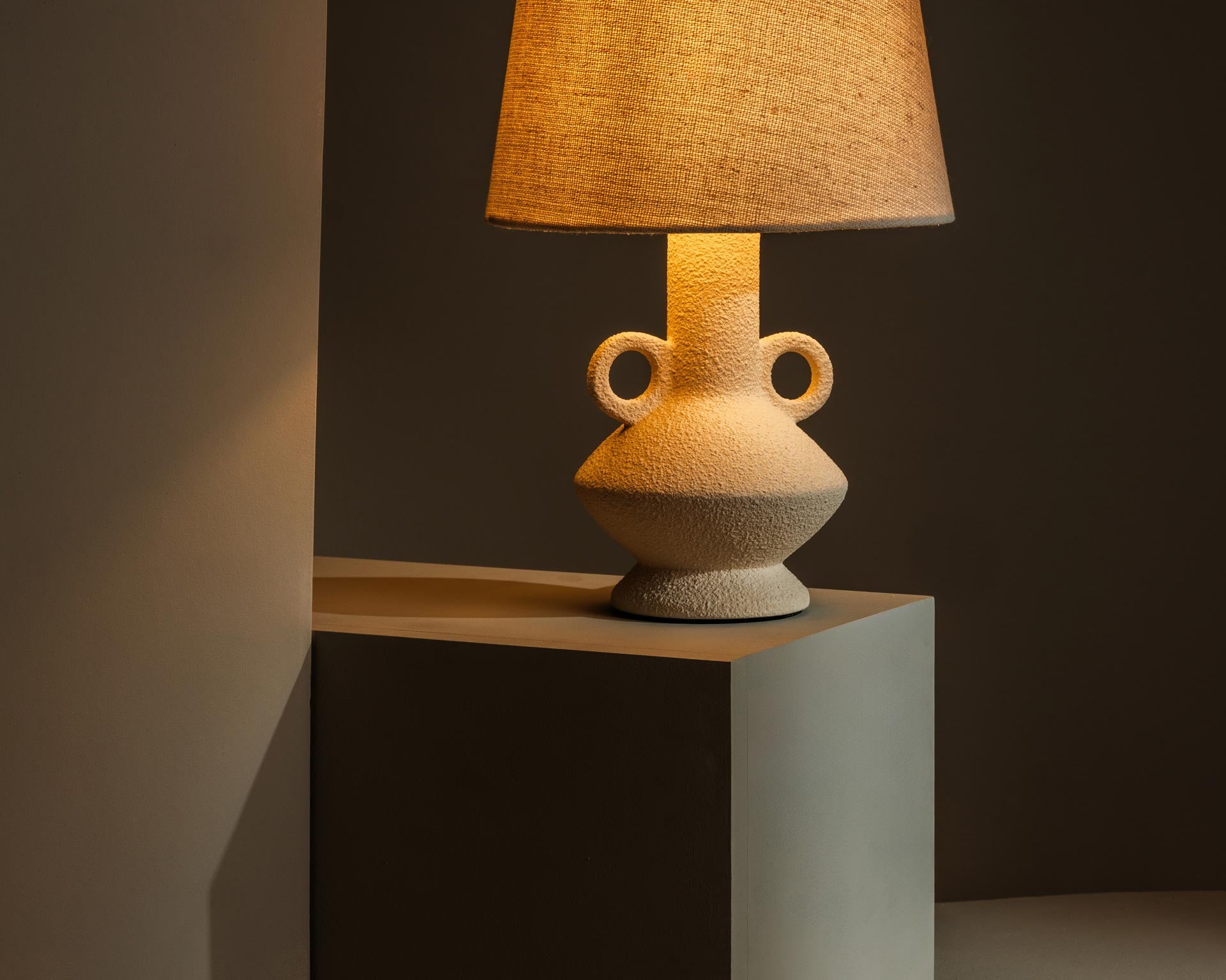 Ceramic table lamp casting warm, atmospheric light - Anboise