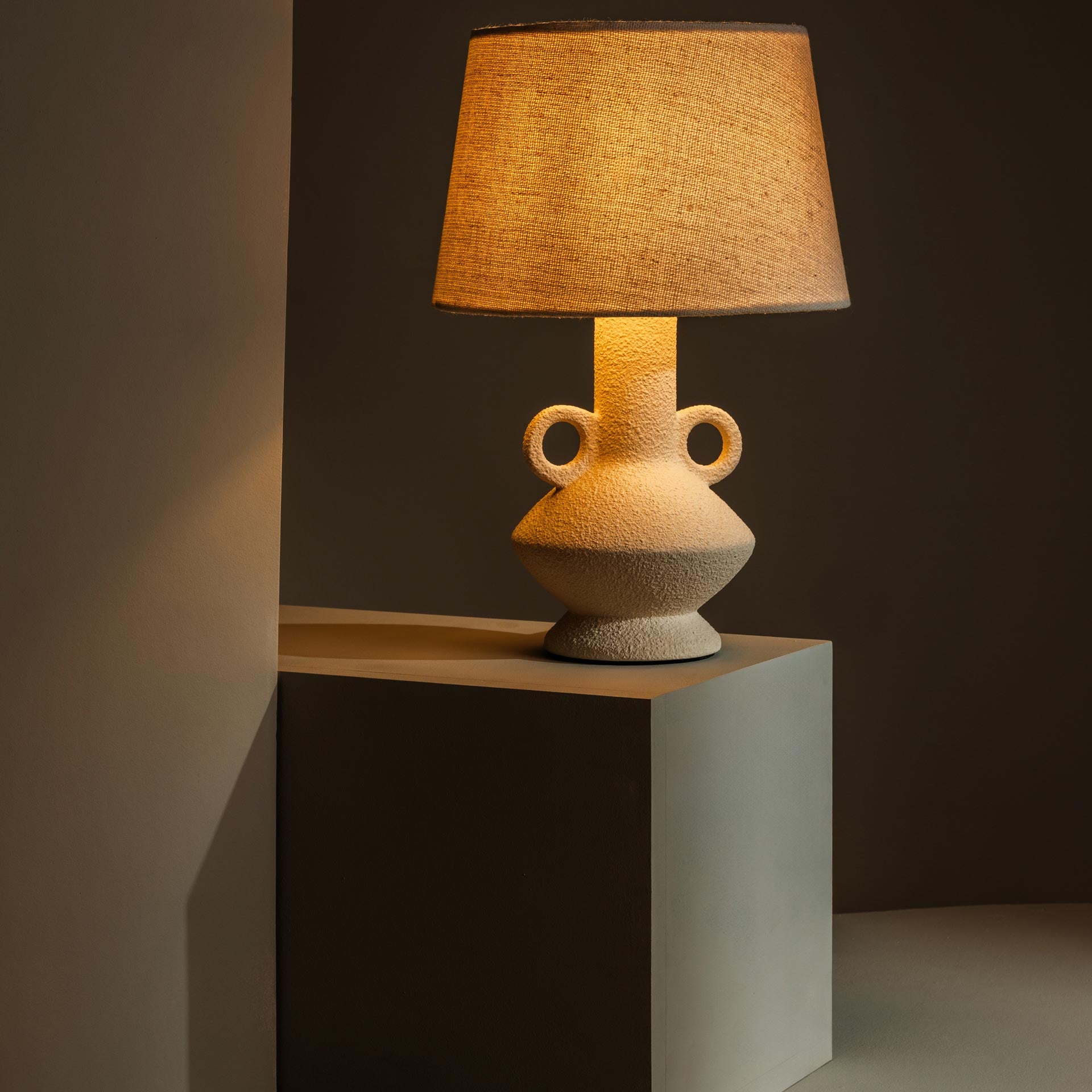 Ceramic table lamp casting warm, atmospheric light - Anboise
