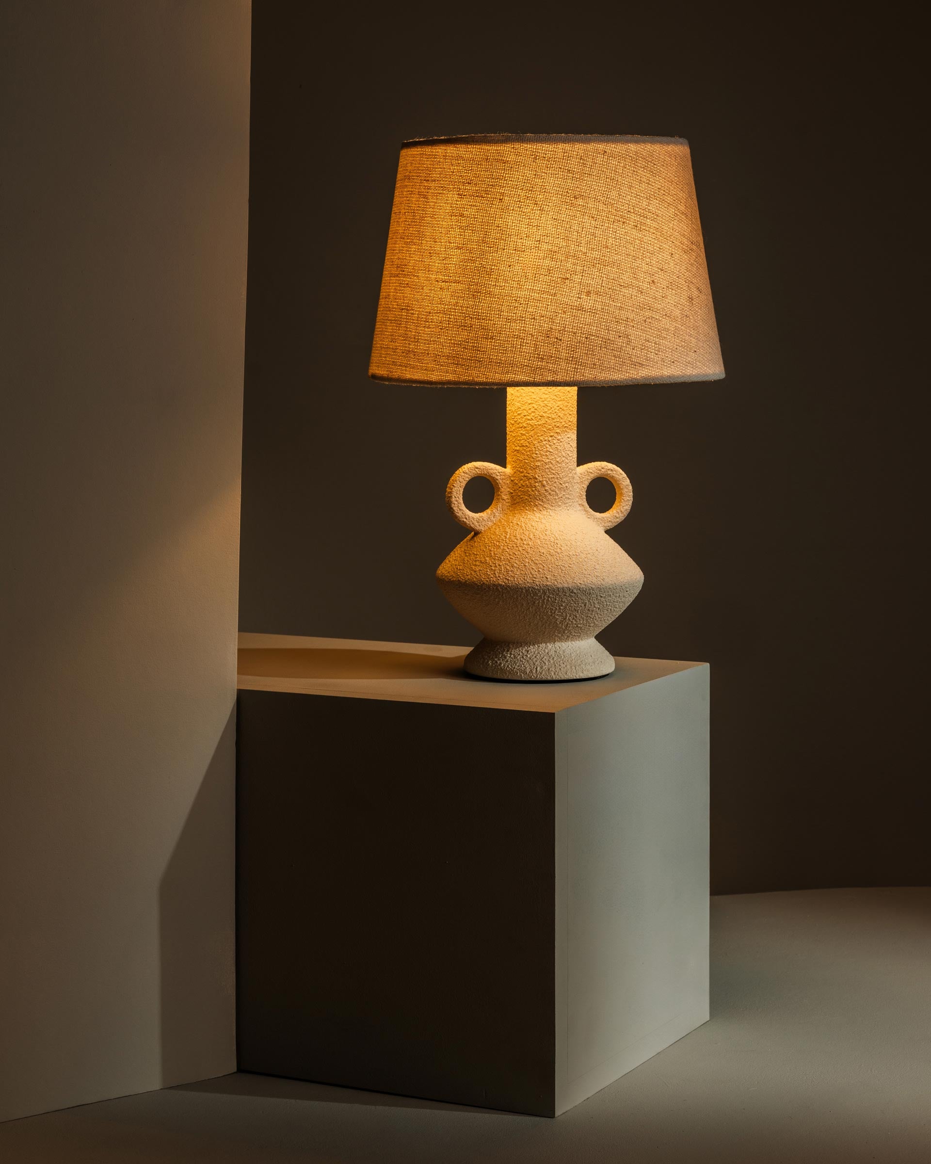 Ceramic table lamp casting warm, atmospheric light - Anboise
