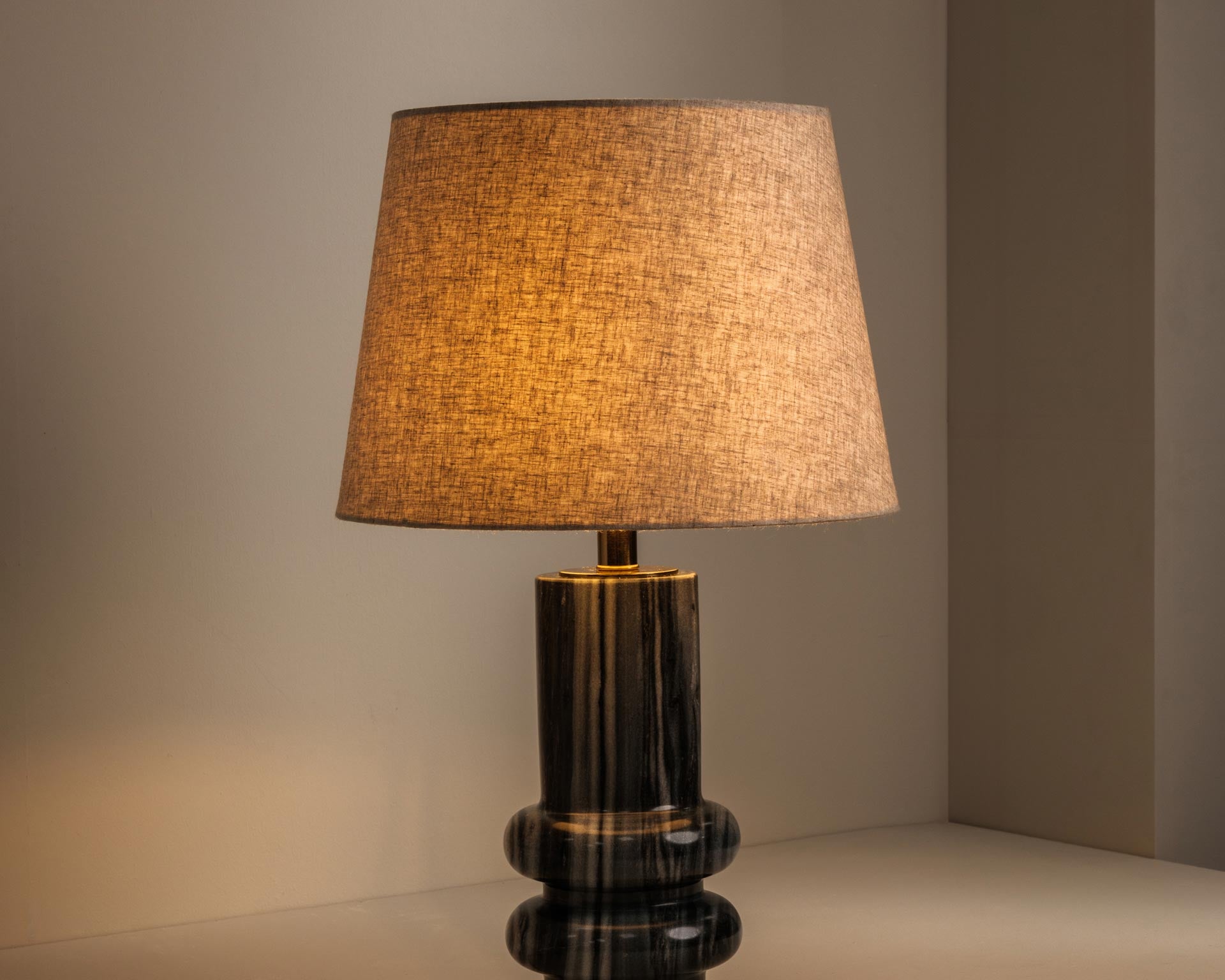 Grey marble table lamp casting warm, atmospheric light - Anboise