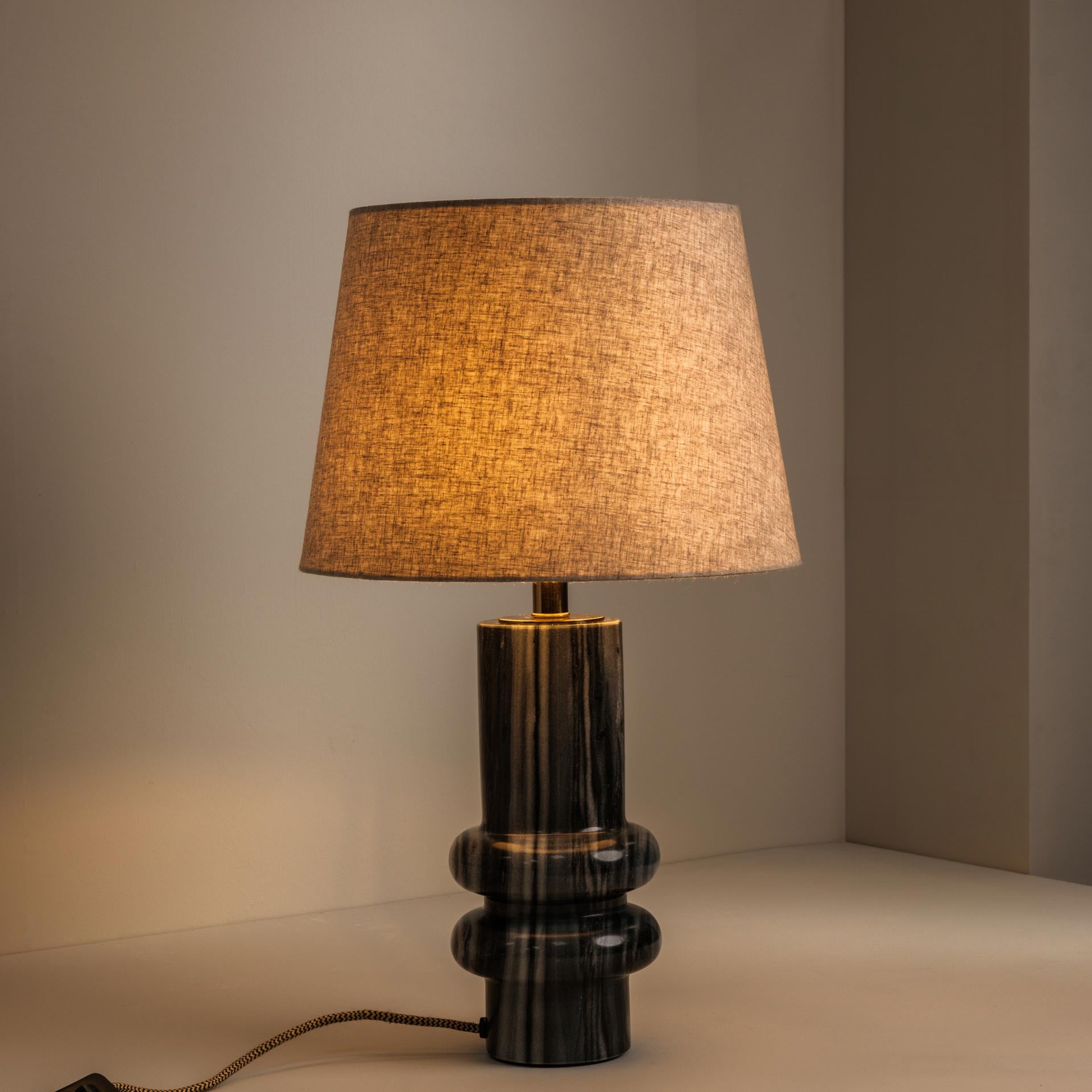 Grey marble table lamp casting warm, atmospheric light - Anboise