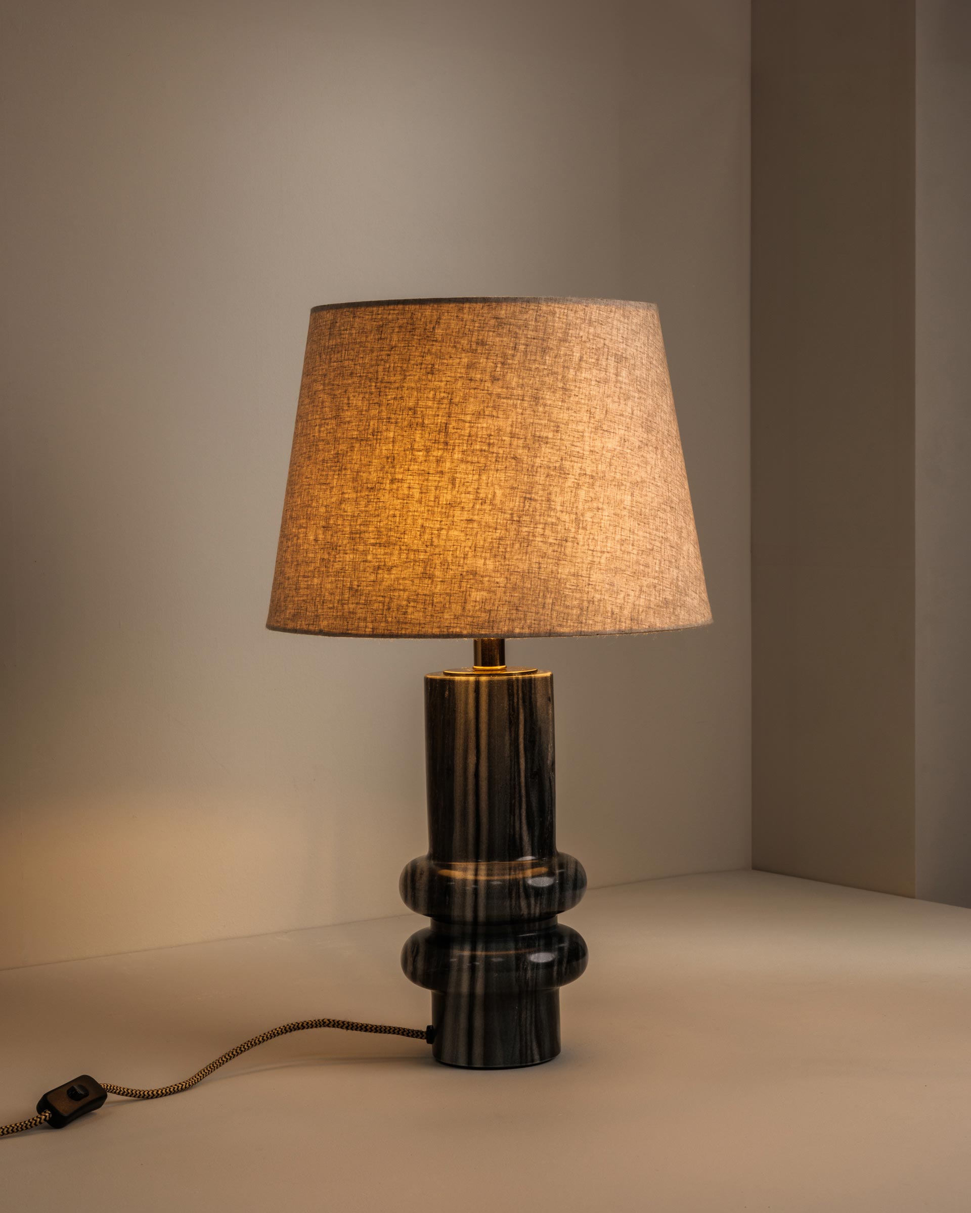 Grey marble table lamp casting warm, atmospheric light - Anboise