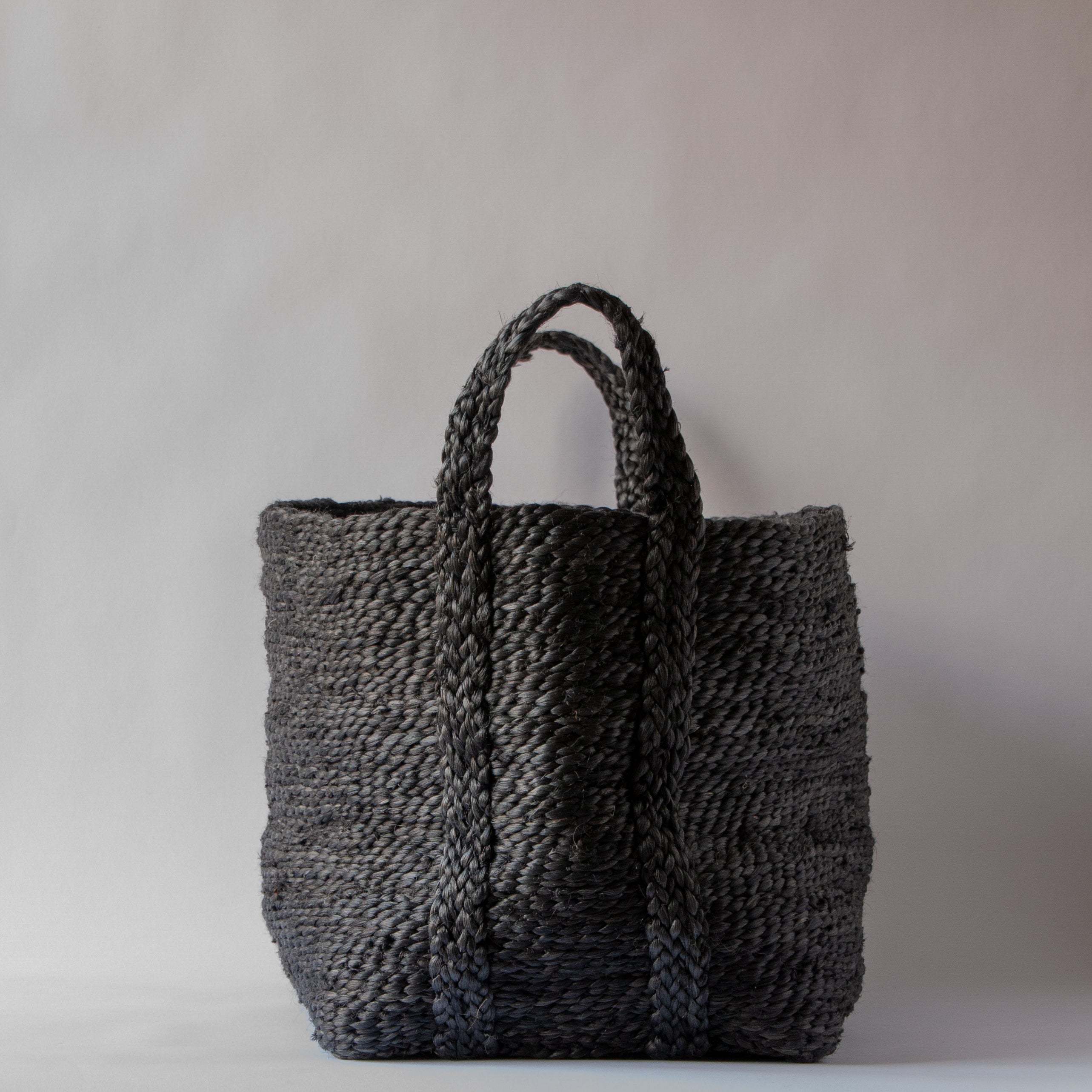 A gray Lucia jute basket with handles, woven from natural materials, displayed against a neutral background.